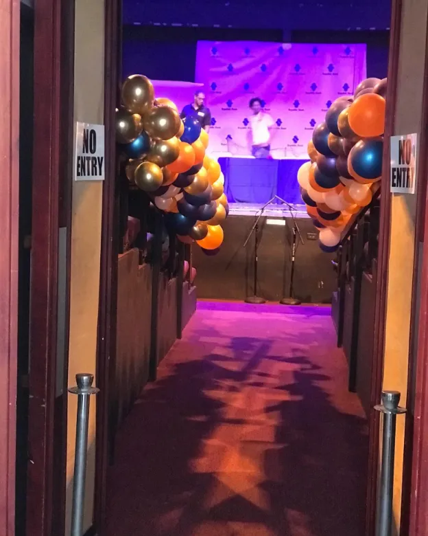 Gold, navy and orange balloon columns framing a corporate event entrance